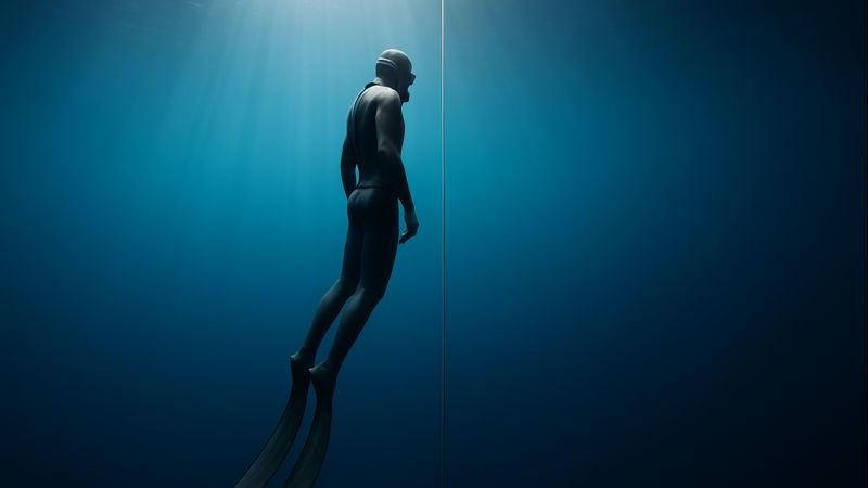 Vabasukelduja laskumas sügavusse sinakas avavees, freediving Eesti